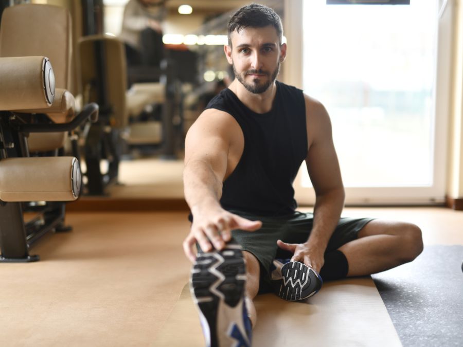 Athlete stretching and recovering in a modern gym